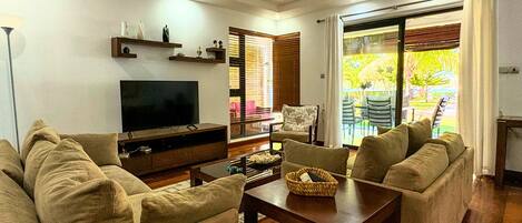 A living room with a TV, sofa, and a dining table.