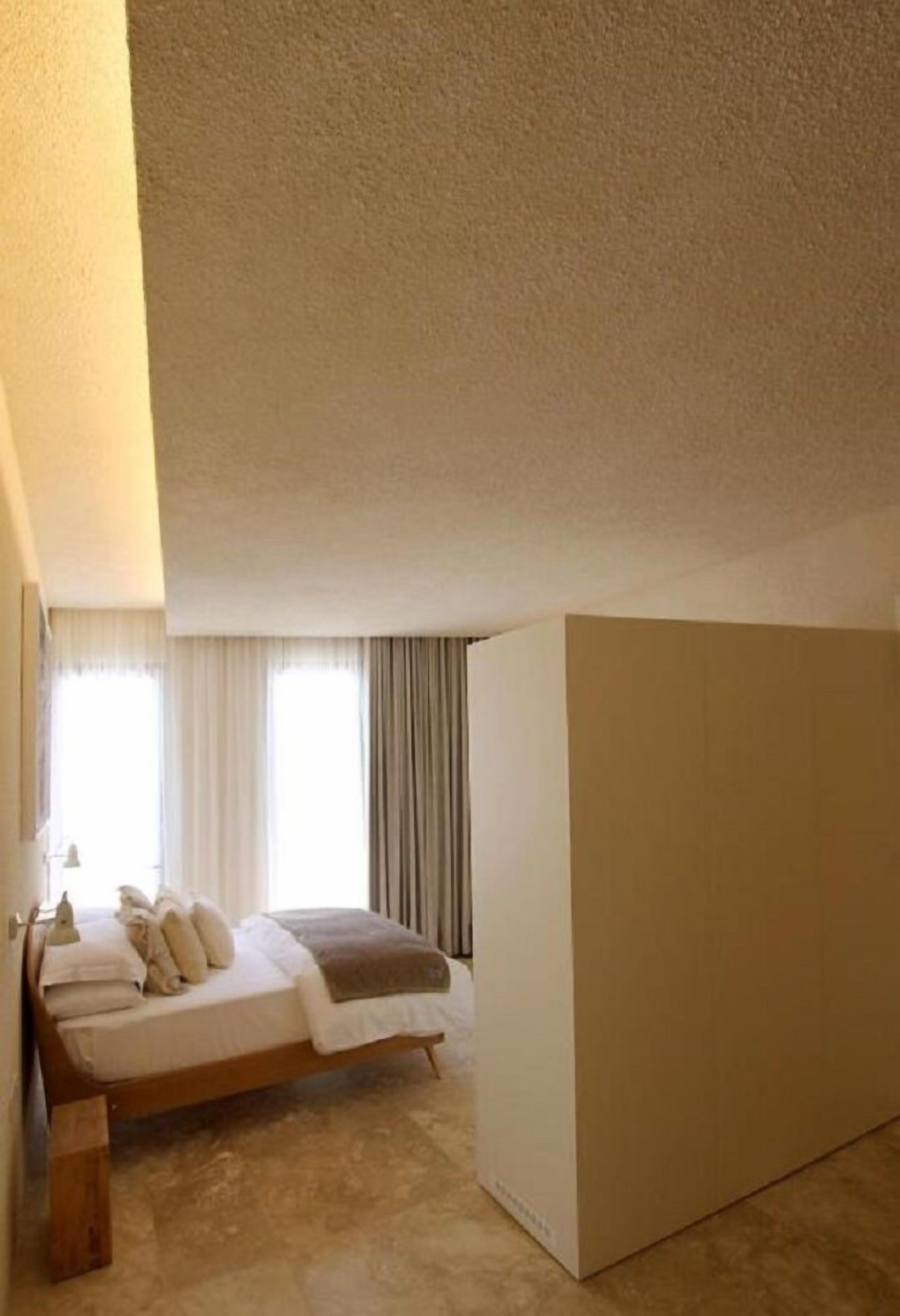 A bedroom with a bed, a nightstand, and a large wardrobe.