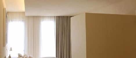 A bedroom with a bed, a nightstand, and a large wardrobe.