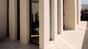 A modern building with a flat roof and large glass doors. - The King George Village Boutique Living (Hal Gharghur)