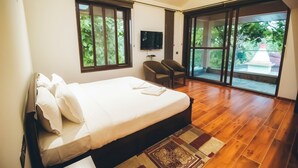 Un dormitorio con una cama grande, televisión y vistas al exterior.