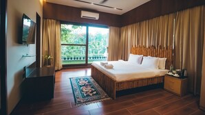 Un dormitorio moderno con una cama grande, ventilador de techo, televisor y ventana con cortinas.