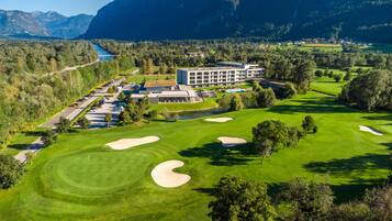 Experience golfing amidst lush greenery and serene surroundings at this resort, set amidst a picturesque valley with mountains in the background.