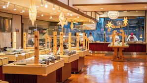 Un buffet avec plusieurs points de service, un éclairage supérieur et un comptoir où les plats sont préparés.