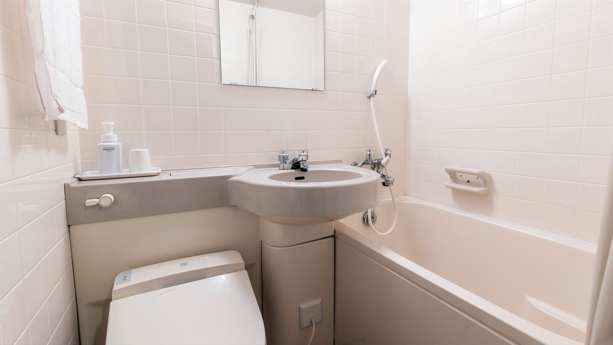 Un baño con lavamanos, inodoro y bañera.