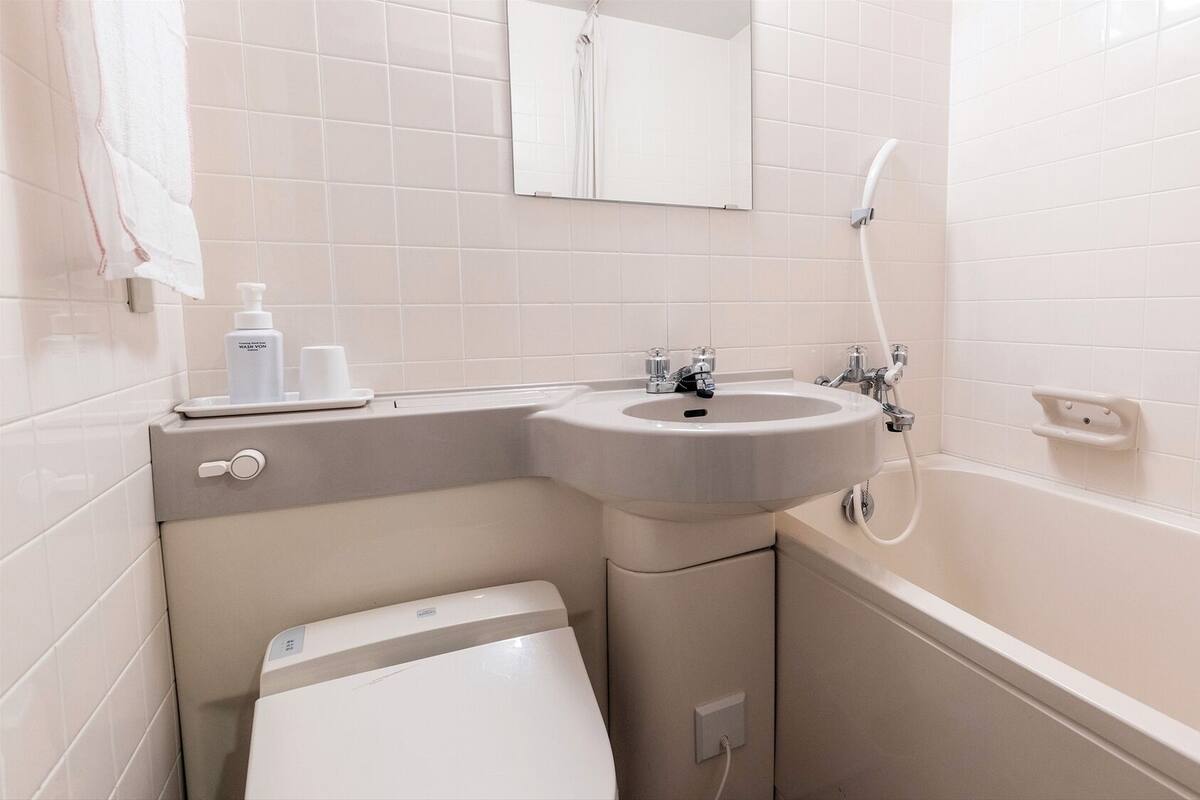 Un baño con lavamanos, inodoro y bañera.