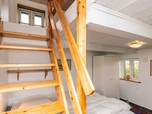A room with a wooden ladder leading to a lofted sleeping area, a bed, and a window with a view. - 5 Person Holiday Home in Veslos (Vesløs)
