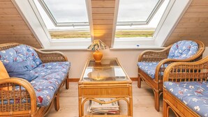 A cozy room with two large windows, wicker furniture, and a glass table. - 5 Person Holiday Home in Veslos (Vesløs)
