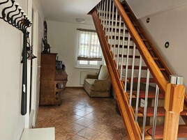 Una escalera con barandillas de madera y peldaños alfombrados de color rojo que conducen a una plataforma.