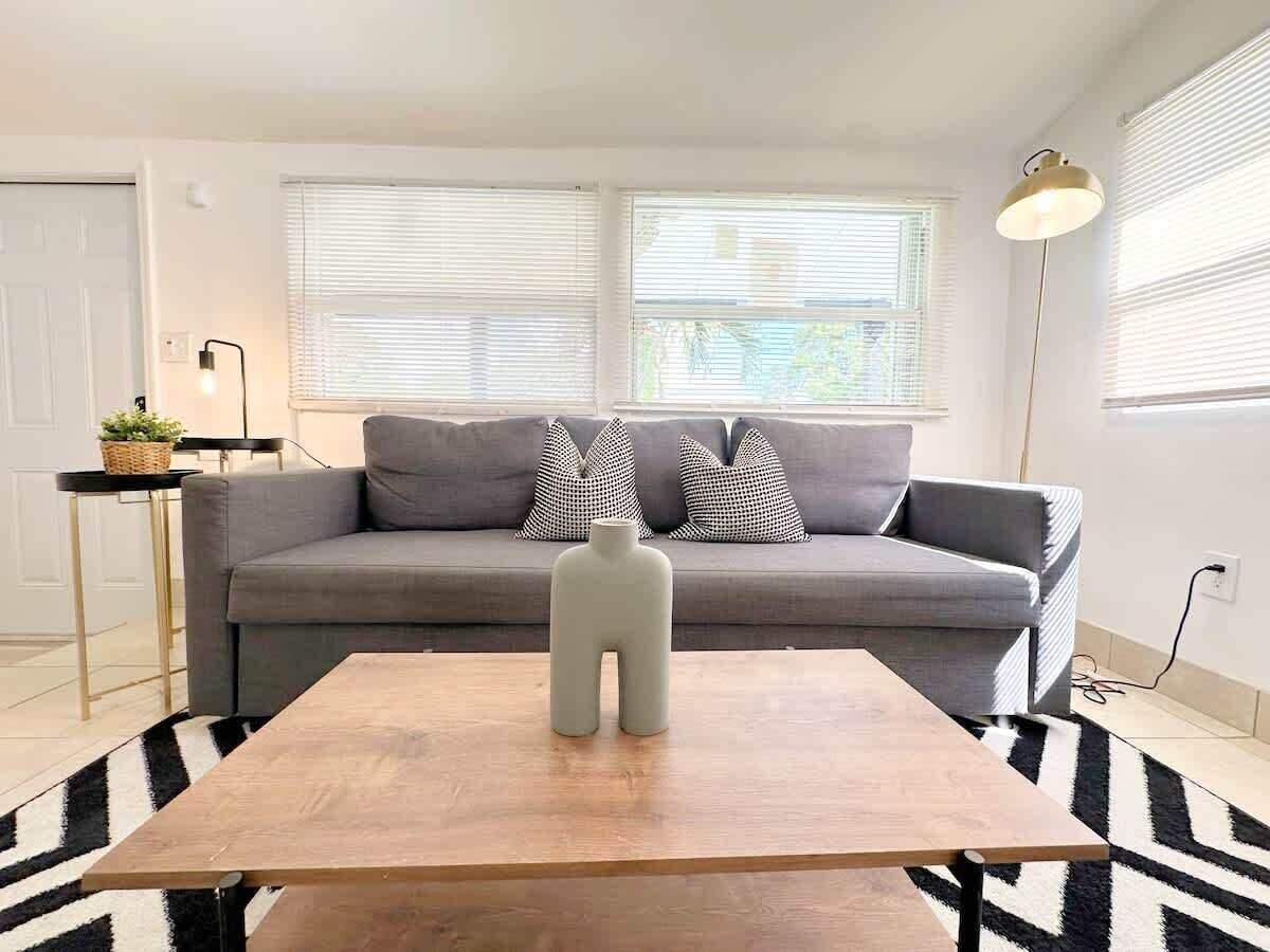 A modern living room with a grey sofa, a wooden coffee table, and a unique decorative piece.