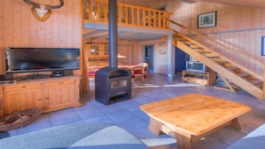 Un intérieur en bois avec une télévision, une cheminée et un escalier en bois.