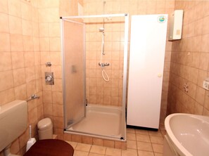 A bathroom with a glass-enclosed shower, a toilet, and a bathtub. - Ferienwohnung, Dornumersiel (Dornum)