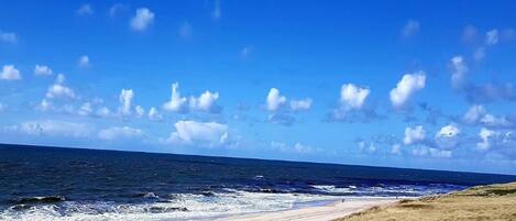 Una playa con cielo despejado y olas.