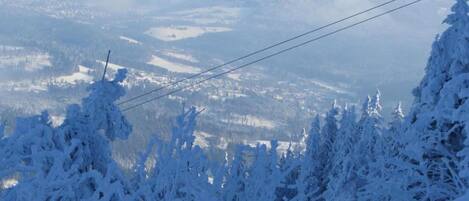A snowy mountain landscape with a clear view of a town below.