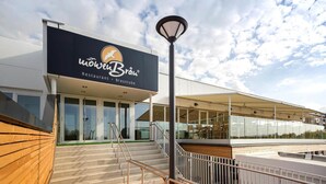 Un ristorante moderno con un cartello che riporta la scritta "MöwenBräu Restaurant - Braustube" e una scala che conduce a una zona salotto all'aperto.