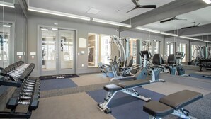 A gym with exercise equipment, mirrors, and a ceiling fan. - Cullen 4307 I Parking I Pool I Gym I 2Bd/2Bth (Houston)