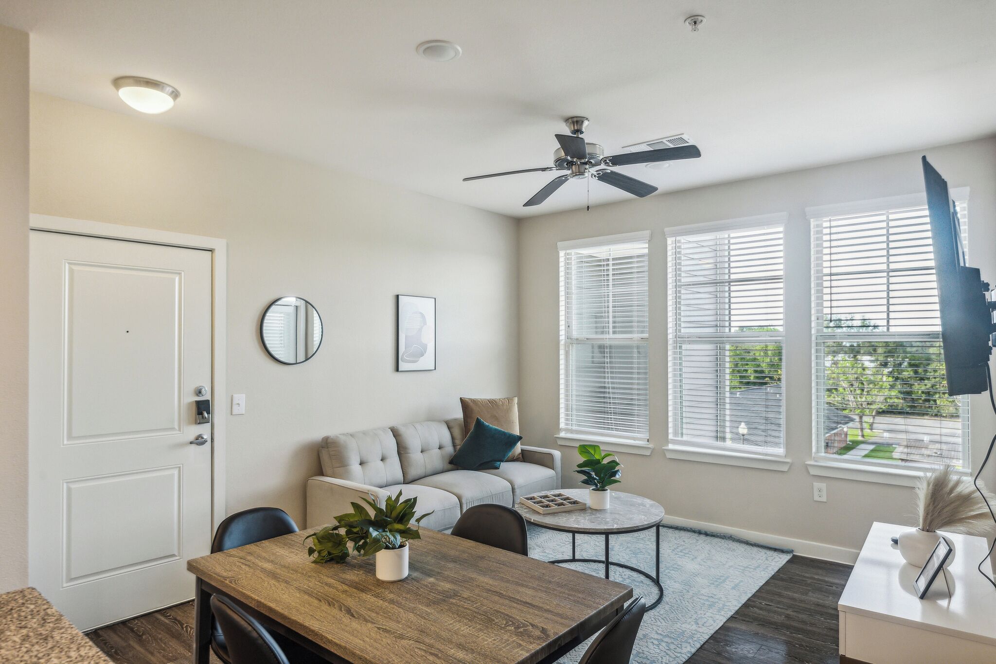 Un salon moderne avec un canapé, une table à manger et un ventilateur de plafond.