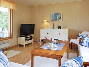 A cozy living room with a television, a white cabinet, a sofa, and a coffee table. - 6 Person Holiday Home in Kungshamn (Kungshamn)