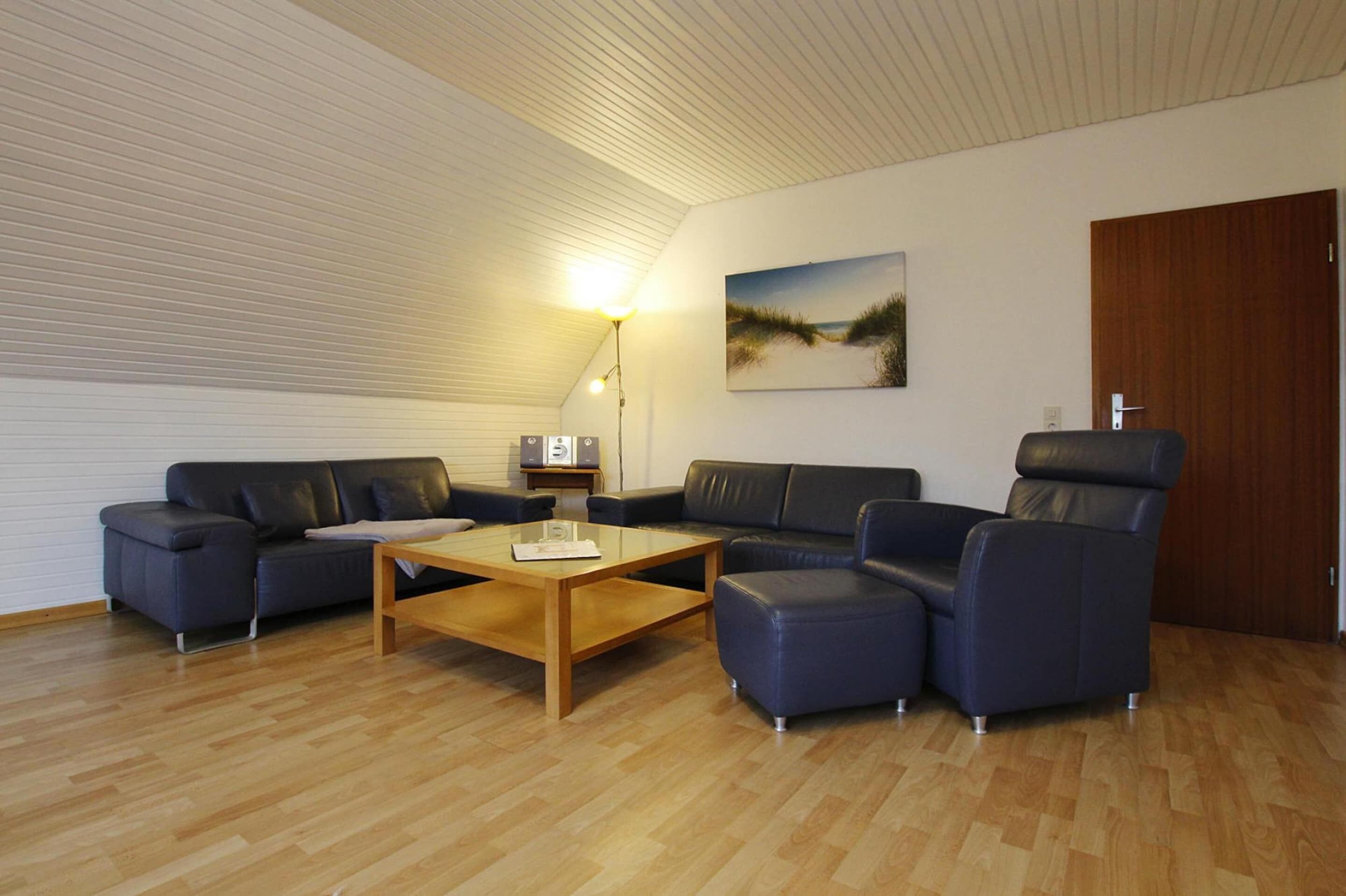 A modern living room with a wooden coffee table, two sofas, and a blue armchair.