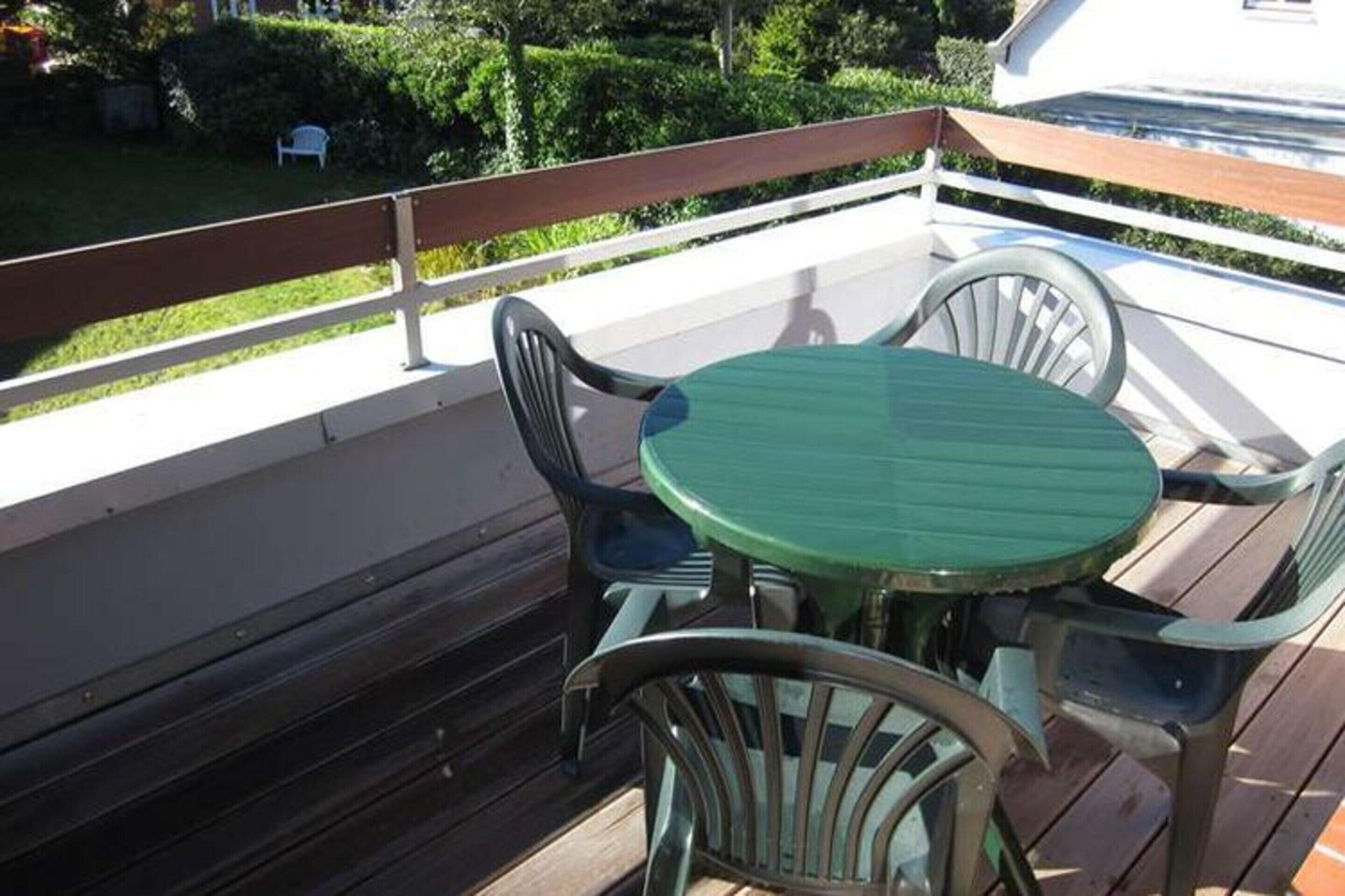 A wooden deck with a round table and four chairs.