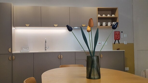 A modern kitchen with a central island, a built-in oven, and a dining area with a table and chairs. - Capital Central Suites No1 - Zekka (Valletta)