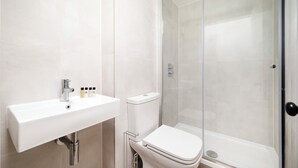 Ein modernes Badezimmer mit Waschbecken, Toilette und einer Duschkabine.