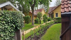 A residential area with a wooden fence, a well-maintained lawn, and houses with brown roofs. - Ferienhaus im Skandinavischen Stil (Mirow)