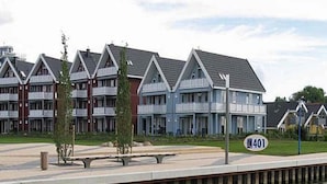Un edificio residenziale sul lungomare con un molo che si protende sull'acqua.