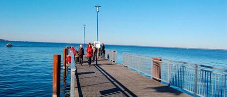 A pier extending into calm blue waters with a clear sky.