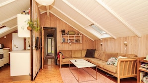 A cozy loft-style living space with a wooden interior, a sofa, a coffee table, and a bookshelf. - Cozy Retreat in Stenstrup - By Traum Ferienwohnungen (Hojby)