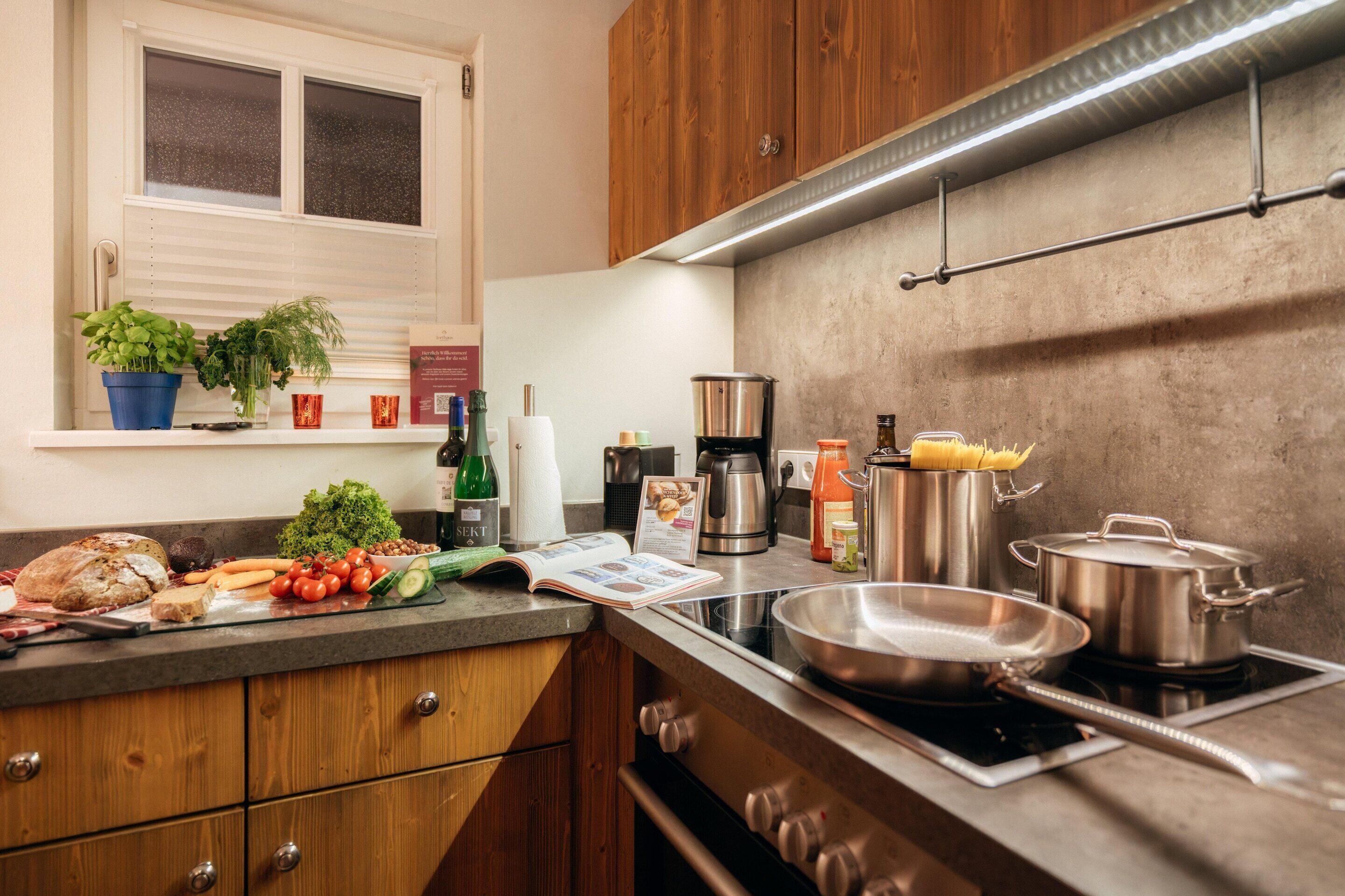 Una cocina moderna con armarios de madera, un ventanal y diversos electrodomésticos.