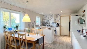 A modern kitchen with a dining area, wooden furniture, and a view of the outdoors. - 4 Star Holiday Home in Kallo-knippla (Källö-Knippla)