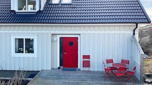 A house with a red door, white siding, and a tiled roof. - 4 Star Holiday Home in Kallo-knippla (Källö-Knippla)