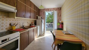 Una cocina compacta con armarios de madera, un microondas y un comedor con mesa y sillas.