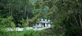 A calm and cosy three-bedroom house in the mountain valleys near Munnar.