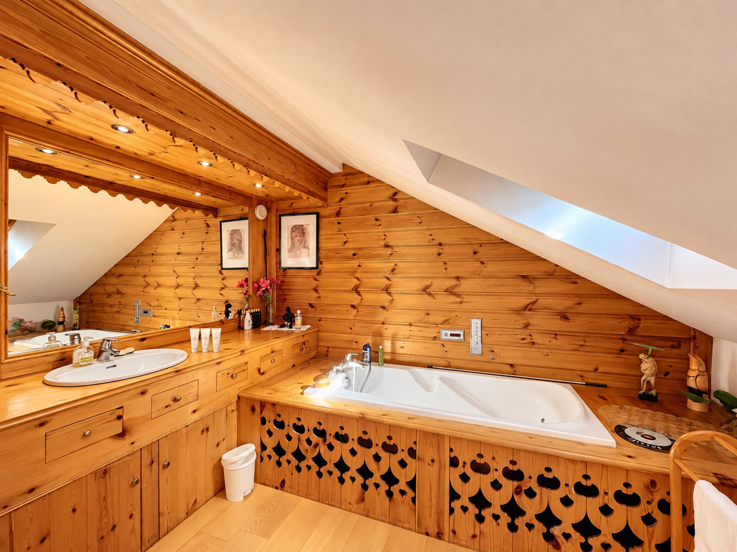 Ein Holzinnenraum mit einer großen Badewanne, Holzschränken und einem Spiegel.