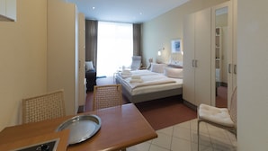 Quarto de hotel moderno com uma cama grande, uma escrivaninha, uma cadeira e uma mesa de jantar.