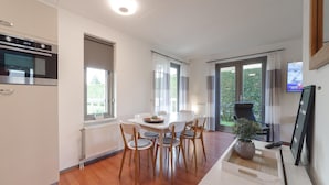 Eine moderne Küche mit Einbauofen und Essbereich mit weißem Tisch und Stühlen.