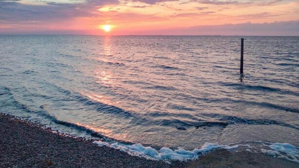 A sunset over a calm sea with gentle waves and a clear sky. - Bungalow in Sondel Near Slotermeer Lake (Sondel)
