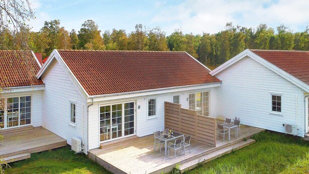A row of white houses with red roofs, each featuring a patio with outdoor furniture. - 4 Star Holiday Home in Laeso (Læsø)