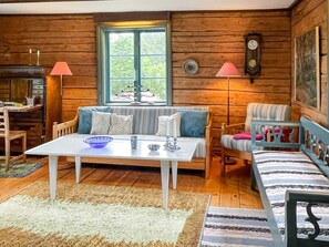A cozy cabin interior with a wooden interior, a dining table, a sofa, and a bench. - 4 Person Holiday Home in Virserum (Virserum)