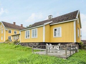 A yellow building with a balcony and outdoor seating. - 4 Person Holiday Home in Virserum (Virserum)