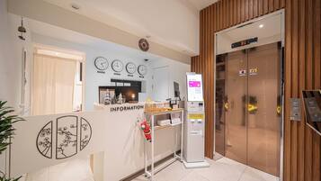A reception area with a desk labeled "INFORMATION," a clock, and an elevator marked "B1."