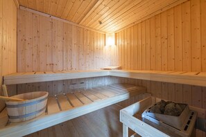 A wooden sauna with benches and a bucket. - Ferienhaus, Friedrichskoog-spitze (Friedrichskoog)