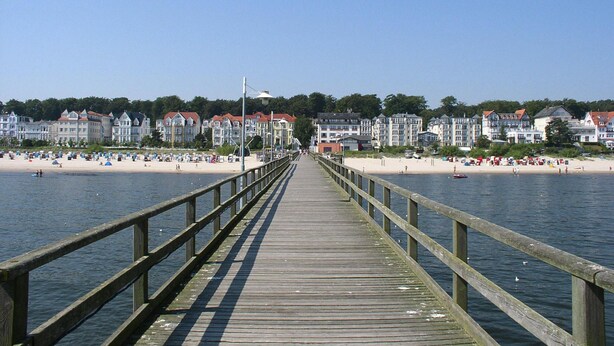A wooden pier leading to a beach with buildings in the background. - Doppelhaushalfte in Bansin (Heringsdorf)