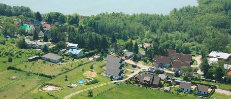 Vista aérea de una zona residencial con casas, un lago y vegetación circundante.