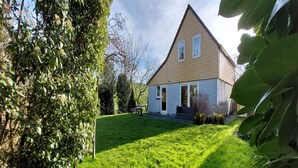 A two-story house with a sloped roof, a front porch, and a well-maintained lawn. - Nice Holiday Home Near Beach (Wemeldinge)