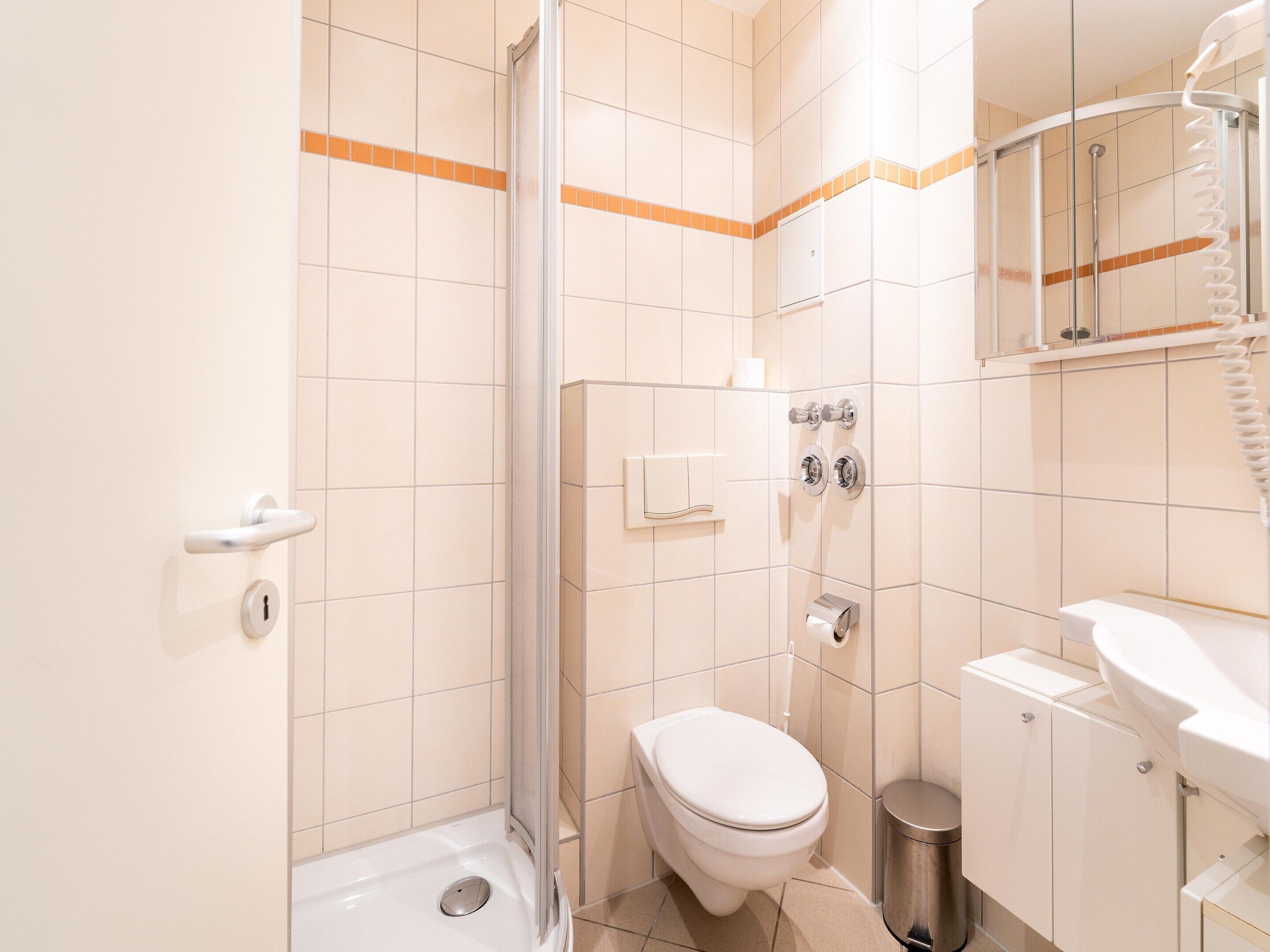 A bathroom with a shower, toilet, and sink.