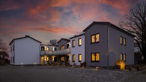 Ein modernes, zweistöckiges Haus mit überdachter Veranda und Auffahrt.