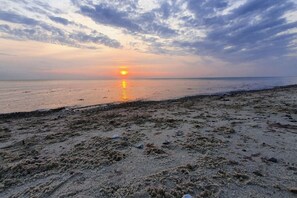 A beach at sunset with a clear sky and calm sea. - Exclusives Appartement auf Fehmarn (Fehmarn)